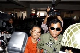 Cảnh sát áp giải ông Hong Sok Hour (giữa) tới tòa án Phnom Penh ngày 2/10. (Nguồn: Reuters/TTXVN)
