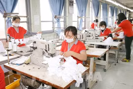 Công nhân dệt may phải giãn ca do thiếu đơn hàng vì COVID-19. (Ảnh: TTXVN)