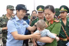 Lực lượng chức năng Việt Nam tiếp nhận em bé bị bán sang Trung Quốc. (Ảnh:Nguyễn Hoàng/TTXVN)