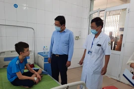 Lãnh đạo Sở Lao động-Thương binh và Xã hội tỉnh Bắc Ninh thăm hỏi, động viên cháu Trương Quang Duy tại Trung tâm Y tế huyện Yên Phong, tỉnh Bắc Ninh. (Ảnh: Thanh Thương/TTXVN)