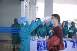 Kiểm tra, cách ly lao động người Trung Quốc để phòng chống bệnh do virus SARS-CoV-2 gây ra. (Ảnh: TTXVN)