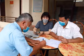 Chi trả tiền hỗ trợ cho người dân gặp khó khăn vì COVID-19. (Ảnh: TTXVN)