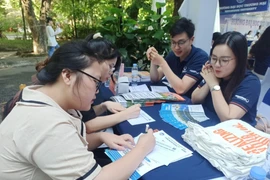 Thí sinh tìm hiểu thông tin tuyển sinh của Trường Đại học Thương mại. (Ảnh: Phạm Mai/Vietnam+)