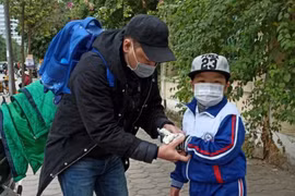 Phụ huynh cần mặc ấm cho con trong ngày giá rét. (Ảnh: Phạm Mai/Vietnam+)