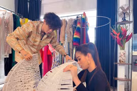 Khánh Vân cùng nhà thiết kế Khoa Lỗ chỉnh sửa lại trang phục dân tộc "Kén Em" lần cuối. (Ảnh: CTV/Vietnam+)