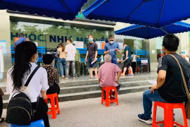 Người dân Thủ đô xếp hàng chờ tiêm chủng COVID-19. (Ảnh minh họa: M.Mai/Vietnam+)