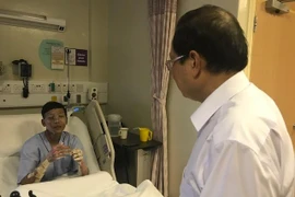 Đại sứ Việt Nam Nguyễn Tiến Minh thăm hỏi anh Phan Minh Dương, một trong ba thuyền viên gặp tai nạn khi đang làm việc trên tàu Le Tong Patriot, Singapore. (Ảnh: Mỹ Bình/Vietnam+)