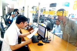 Người dân đến làm thủ tục hành chính tại Trung tâm Hành chính công tỉnh Hòa Bình. (Ảnh: Nhan Sinh/TTXVN)