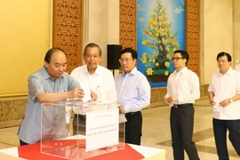 Thủ tướng Nguyễn Xuân Phúc và các Phó Thủ tướng quyên góp ủng hộ đồng bào các tỉnh miền Trung khắc phục hậu quả cơn bão số 10. (Ảnh: Thống Nhất/TTXVN)