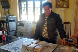 Đối tượng Lầu A Của cùng tang vật tại cơ quan điều tra Công an tỉnh Lai Châu. (Ảnh: Công Hải/TTXVN)