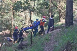 Lực lượng cứu hộ đưa thi thể hai nạn nhân xấu số lên khỏi thác Hang Cọp. (Ảnh: Nguyễn Dũng/TTXVN)