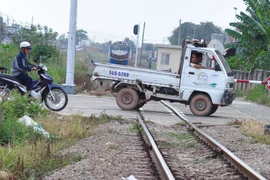 Đường ngang dân sinh ở phường Tân Hòa, Biên Hòa (Đồng Nai) người tham gia giao thông vẫn cố tình băng qua đường sắt dù tàu đang đến gần. (Ảnh: Công Phong/TTXVN)