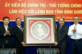 Thủ tướng Nguyễn Xuân Phúc trao tặng biểu tượng “Mặt trống đồng Ngọc Lũ” cho tỉnh Bình Dương. (Ảnh:Thống Nhất/TTXVN)