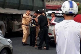 Lực lượng chức năng khống chế đối tượng vi phạm. (Ảnh: TTXVN phát)