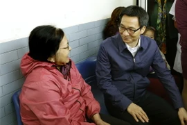 Phó Thủ tướng Vũ Đức Đam trao đổi với người dân đến khám, chữa bệnh tại trạm y tế phường Tây Mỗ. (Ảnh: Dương Ngọc/TTXVN)