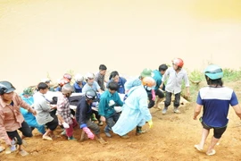 Chuyển nạn nhân về nhà để làm thủ tục mai táng. (Ảnh: Đinh Hữu Dư/TTXVN)