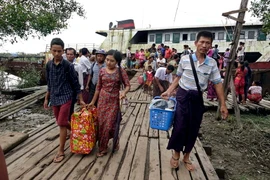 Người dân sơ tán khỏi thị trấn Maungdaw, bang Rakhine để tránh bạo lực ngày 26/8. (Nguồn: EPA/TTXVN)