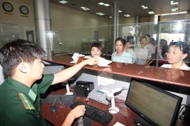 Bộ đội Biên phòng làm thủ tục nhập cảnh cho du khách Trung Quốc. (Ảnh: Trọng Đức/TTXVN)