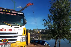 Xe khách rơi xuống hồ Xuân Hương đang được lực lượng cứu hộ trục vớt. (Ảnh: Đặng Tuấn/TTXVN)