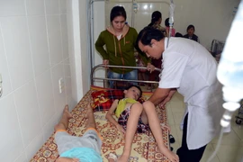 Các y, bác sỹ Trạm y tế phường Nghi Hòa, Thị xã Cửa lò (Nghệ An) đang cấp cứu, điều trị cho các em học sinh bị ngộ độc. (Ảnh: Tá Chuyên/TTXVN)