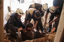 Giúp đỡ một nạn nhân bị thương trong cuộc không kích ở Daraa, Syria, ngày 8/4. (Nguồn: AFP/TTXVN)