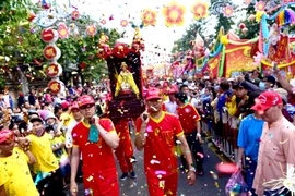 Người dân và du khách xem rước kiệu bà Thiên Hậu trên phố trong Lễ hội chùa Bà Thiên Hậu ở thành phố Thủ Dầu Một. (Ảnh: Huyền Trang/TTXVN)