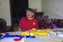 Đối tượng Phimxi Xukha Mixay cùng tang vật tại cơ quan điều tra. (Nguồn: TTXVN)