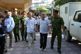 Dẫn giải bị cáo Bạch Văn Đông và Nguyễn Tiến Triển vào phòng xét xử. (Ảnh: Nguyễn Văn Cảnh/TTXVN)