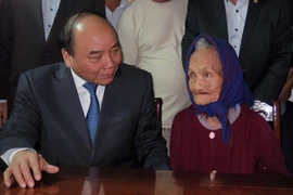 Thủ tướng Nguyễn Xuân Phúc thăm hỏi và tặng quà mẹ Nguyễn Thị Hân. (Ảnh: Nguyễn Sơn/TTXVN)