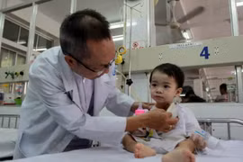 Bác sỹ Nguyễn Thế Huy, Phó trưởng khoa Tai Mũi Họng, Bệnh viện Nhi đồng 1 Thành phố Hồ Chí Minh thăm khám cho bệnh nhi. (Ảnh: Phương Vy/TTXVN)