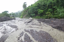 Quốc lộ 12 có nguy cơ bị chia cắt tại km119 do đất đá từ ta-luy dương vẫn còn chảy xuống mặt đường. (Ảnh: Xuân Tiến/TTXVN)