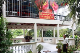 Ông Sơn bên ngôi nhà thờ Bác của gia đình. (Ảnh: Lê Sen/TTXVN)