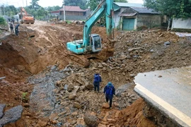 Chính quyền địa phương đã khẩn cấp huy đọng các lực lượng giúp 5 hộ dân cạnh hỗ cáttơ di dời lên vị trí an toàn. (Ảnh: Quang Duy/TTXVN)