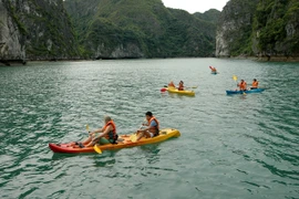 Du khách bơi thuyền Kayak trên Vịnh Hạ Long. (Ảnh: Tiến Dũng/TTXVN)