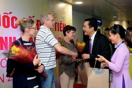 Ông Bùi Tá Hoàng Vũ, Giám đốc Sở du lịch Thành phố Hồ Chí Minh tặng quà cho đoàn khách du lịch quốc tế đầu tiên trong năm 2017. (Ảnh: An Hiếu/TTXVN)