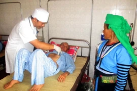 Bác sỹ Bệnh viện Đa khoa huyện Mường Lát khám cho bệnh nhân đến từ tỉnh Huaphanh. (Ảnh: Nguyễn Nam/TTXVN)