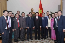 Phó Thủ tướng, Bộ trưởng Bộ Ngoại giao Phạm Bình Minh chụp ảnh chung với đoàn đại biểu cấp cao Trung ương Đoàn Thanh niên Nhân dân Cách mạng Lào. (Ảnh: Phương Hoa/TTXVN)