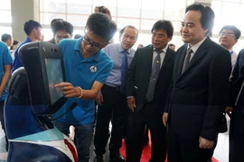 Bộ trưởng Bộ Giáo dục và Đào tạo Phùng Xuân Nhạ tham quan sản phẩm robot tiếp tân do sinh viên trường Đại học Sư phạm Kỹ thuật Thành phố Hồ Chí Minh chế tạo. (Ảnh: Phương Vy/TTXVN)