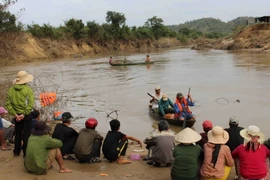 Lực lượng chức năng huyện Krông Bông tìm kiếm thi thể nạn nhân mất tích trên sông Krông Ana. (Ảnh: Phạm Cường/TTXVN)