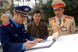 Lực lượng chức năng lập biên bản xử lý các trường hợp vi phạm. (Ảnh: Mạnh Tú/TTXVN)