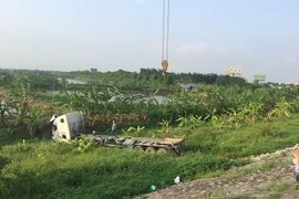 Lực lượng chức năng cứu hộ cẩu xe lên khỏi hiện trường. (Ảnh: Hiền Anh/TTXVN)