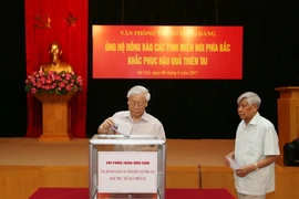 Tổng Bí thư Nguyễn Phú Trọng, nguyên Tổng Bí thư Lê Khả Phiêu tham gia quyên góp ủng hộ đồng bào các tỉnh miền núi phía Bắc. (Ảnh: Trí Dũng/TTXVN)