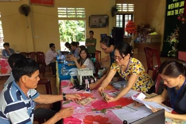 Người dân thôn Vịnh Mốc, xã Vĩnh Thạch, huyện Vinh Linh, tỉnh Quảng Trị làm thủ tục nhận tiền đền bù sự cố môi trường biển. (Ảnh Trần Tĩnh/TTXVN)