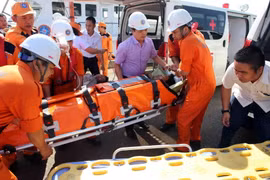 Chuyển thuyền viên gặp nạn từ tàu SAR 412 lên bờ để đưa vào bệnh viện Đà Nẵng tiếp tục điều trị. (Ảnh: Trần Lê Lâm/TTXVN)