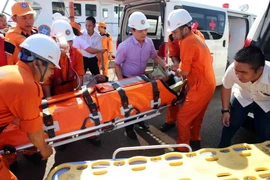 Chuyển thuyền viên gặp nạn từ tàu SAR 412 lên bờ để đưa vào bệnh viện Đà Nẵng tiếp tục điều trị. (Ảnh: Trần Lê Lâm/TTXVN)