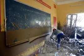 Lực lượng chức năng thu dọn những đồ vật còn sót lại tại một trường học ở thị trấn Mù Cang Chải. (Ảnh: Tuấn Anh/TTXVN)
