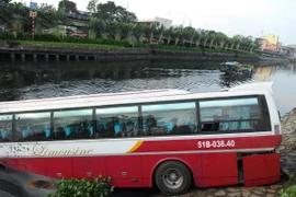 Chiếc xe khách loại 46 chỗ đang lưu thông trên đường Võ Văn Kiệt, đã đâm hàng loạt dải phân cách cứng rồi lao xuống kênh. (Ảnh: Mạnh Linh/TTXVN)