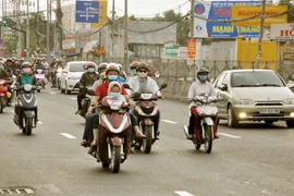 Người dân về Thành phố Hồ Chí Minh bằng xe máy tại nút giao thông Bình Chánh sau kỳ nghỉ Tết Nguyên đán. (Ảnh: Tuấn Anh/TTXVN phát)