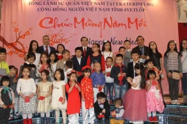 Các cháu nhỏ được nhận lì xì tại buổi gặp mặt. (Ảnh: Dương Trí/Vietnam+)