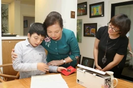 Phu nhân Chủ tịch nước Trần Đại Quang, bà Nguyễn Thị Hiền tặng quà cho bé ​Nem. (Ảnh: Doãn Tấn/TTXVN)